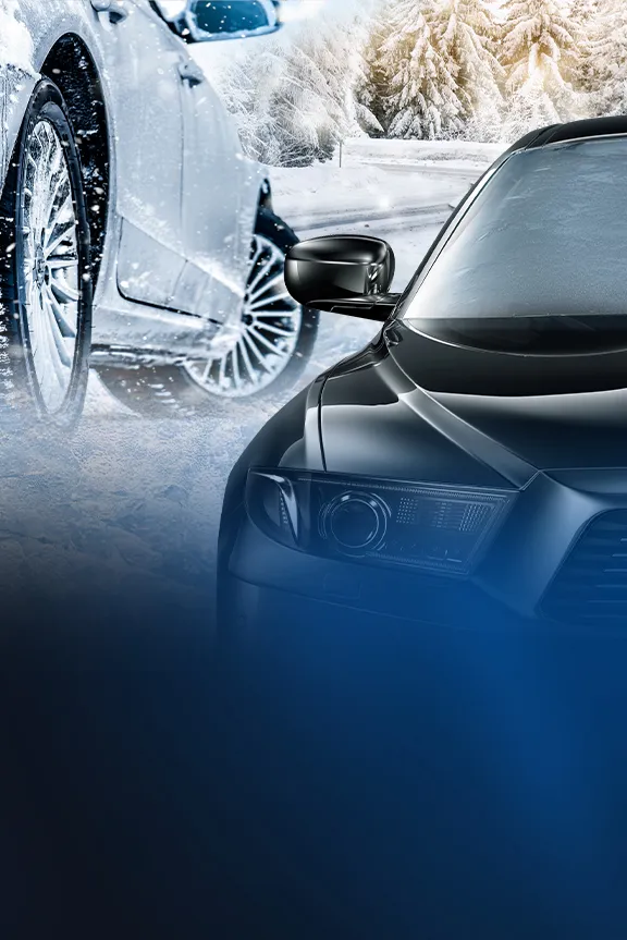 Nahaufnahme eines schwarzen Autos auf einer verschneiten Straße im Winterwald bei Sonnenuntergang.